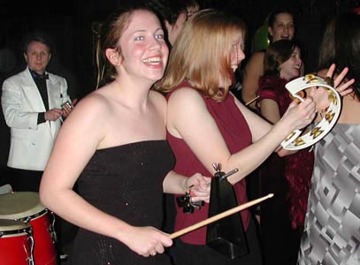 Playing along with the band brings smiles to the faces of enthusiatic cowbell and tambourine players.