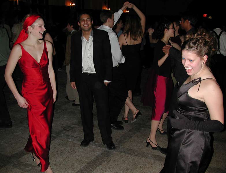Dancers laugh and watch other dancers.