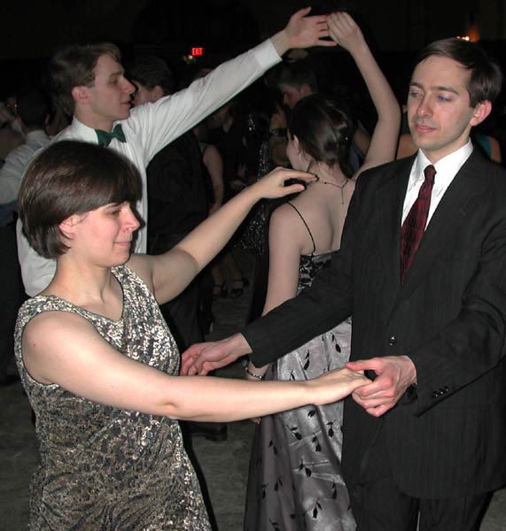 Dancers in the background execute an under-the-arm turn while others in the foreground prepare to do the same.