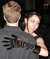 Black satin gloves contrast with a flannel shirt.