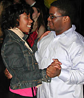 A casually dressed couple dances to a slow ballad.