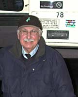 Frank smiles inside the bus, with the bus rules in the background.