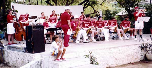 The band plays on a stone and adobe stage in a park. Bigger picture is 92K.
