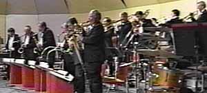 The sax, trombone, and trumpet sections all stand.
