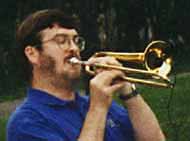 Glen plays a soprano trombone in a Roseville Big Band concert in Central Park, with a clip-on microphone for the CTV15 community access television live broadcast.