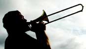 Silhouetted against the sky, Glen Newton plays an alto trombone solo.