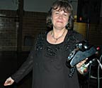 Mary holds the telephone toward the camera.