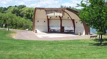 A carpet of green lawn leads down to the band shell.