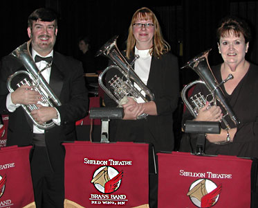 Glen, Cami, and Mary stand, holding their horns.