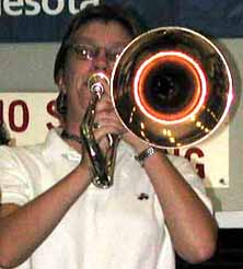 Julie plays her trombone at the camera.