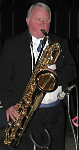 Bill stands and plays his baritone sax while watching the dancers.