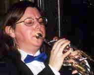 Kim plays trumpet in formal attire.