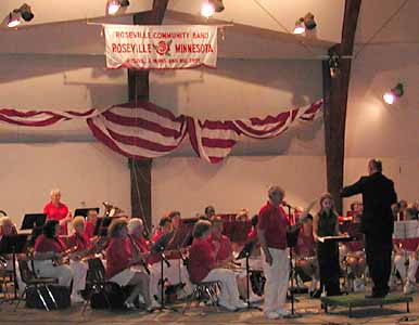 Dan Kuch, in suit with back to camera, directs the Roseville Community Band shortly before the fireworks.