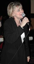 Dorothy sings with a hand-held microphone.