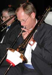 Tom plays trombone with a red and white cup mute.