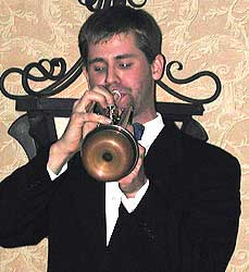 John plays trumpet with a copper wah-wah mute, stem removed.