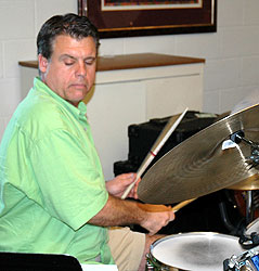 Dave looks down at the music while his sticks fly.