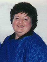 Barb smiles at the camera, wearing a sparkly dark blue top.