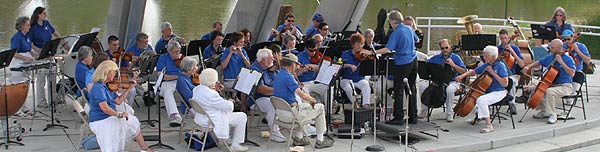 The St. Anthony Civic Orchestra plays at the water's edge.