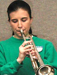 Sarah in a green sweatshirt playing trumpet.