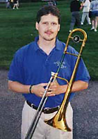 Rich poses with his trombone, wearing a Roseville Big Band summer shirt.